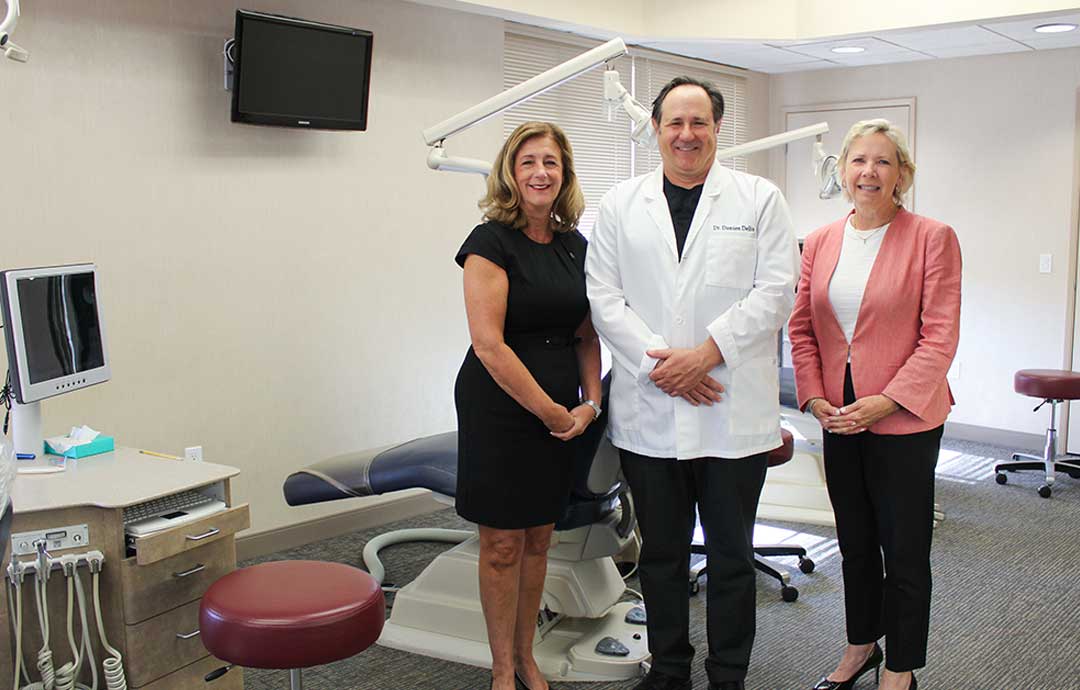 2 women and 1 man standing in a dentist office