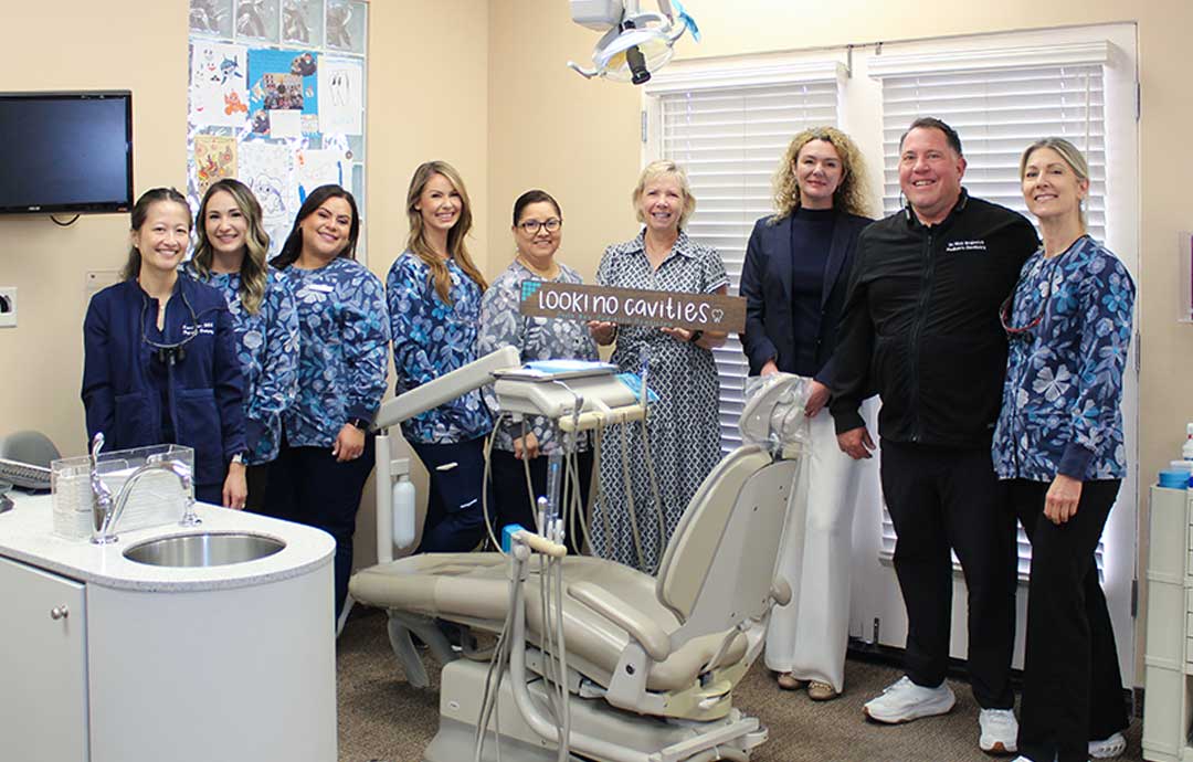 group of women and a man standing in a dentists office