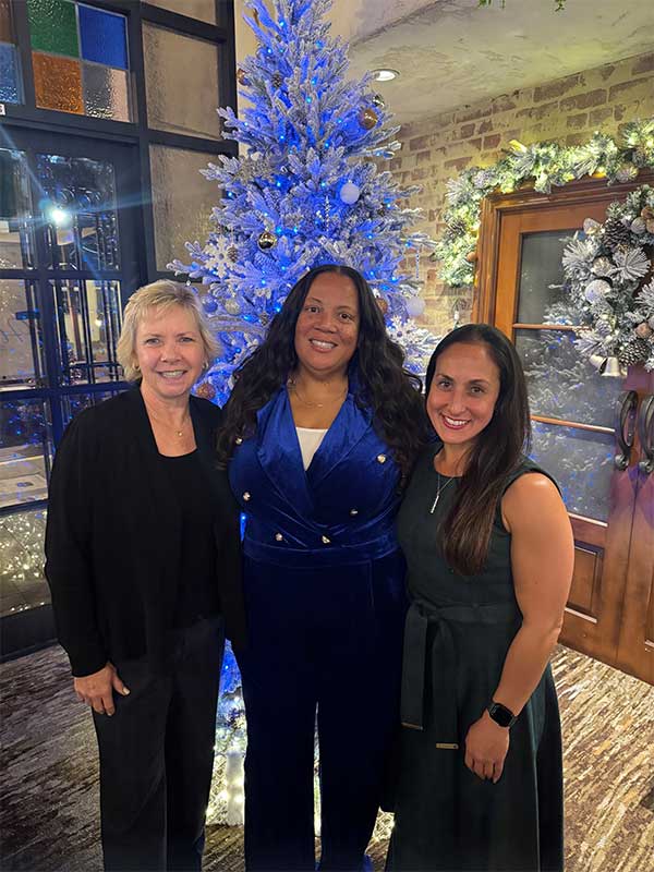 Three women standing in front of a christmas tree