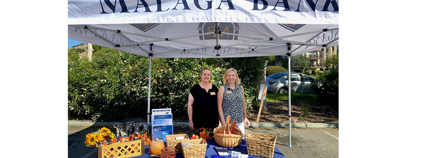 sacha and julia standing in malaga bank's harvest booth