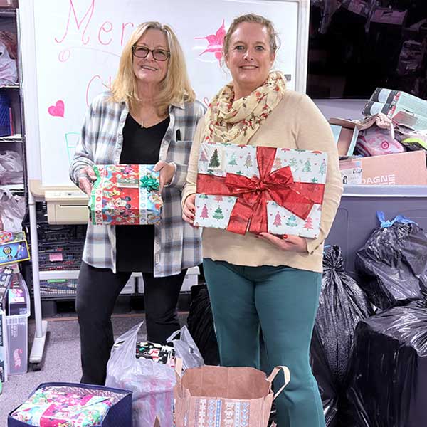 2 women holding christmas gift boxes