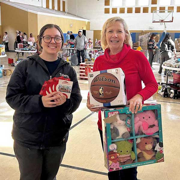 2 women holding basketball and gift card gifts
