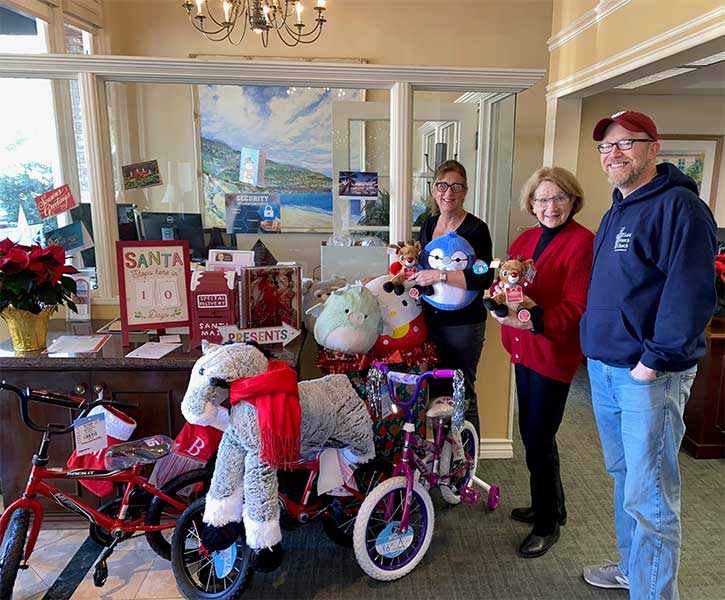 group of people holding toys for donations
