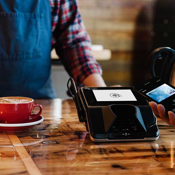 person buying coffee using their debit card for payment
