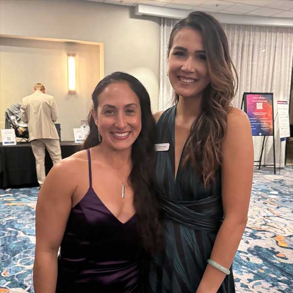 two women dressed in formal dresses