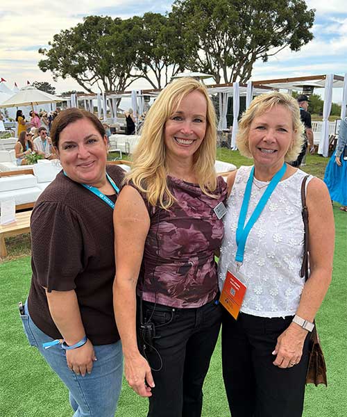 3 women standing at outdoor toast for the coast event