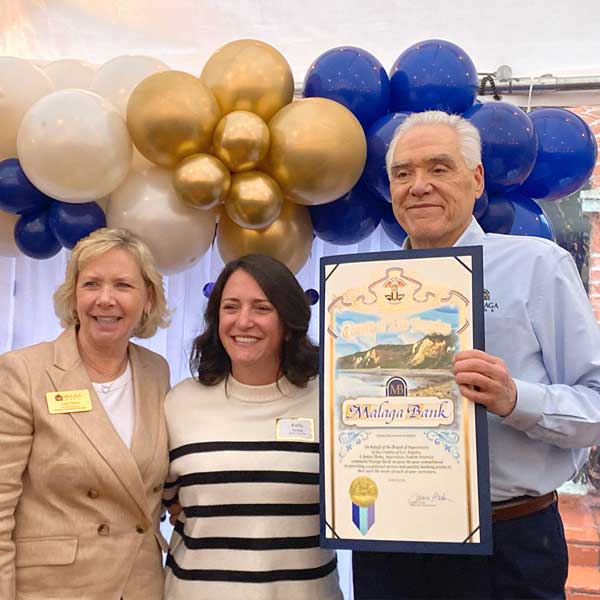 Two women and one man accepting a certificate