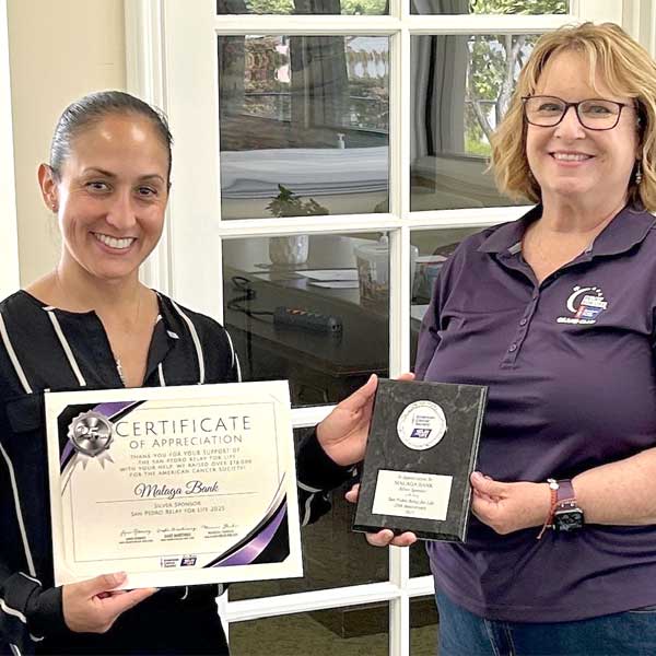 Two women looking a certificate