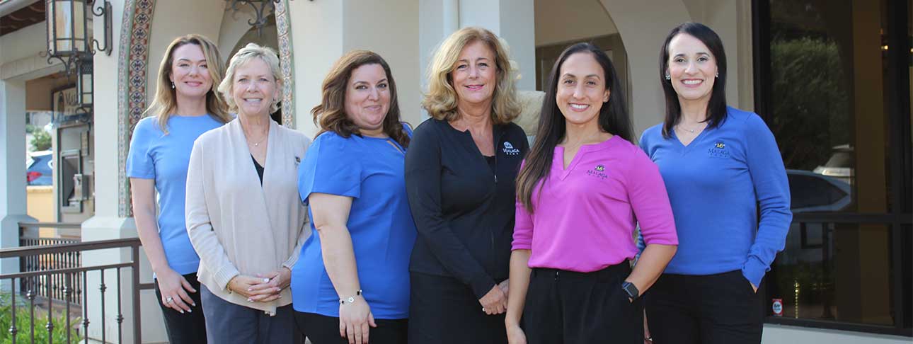 group of women standing in front of Malaga Bank's fountain in Torrance